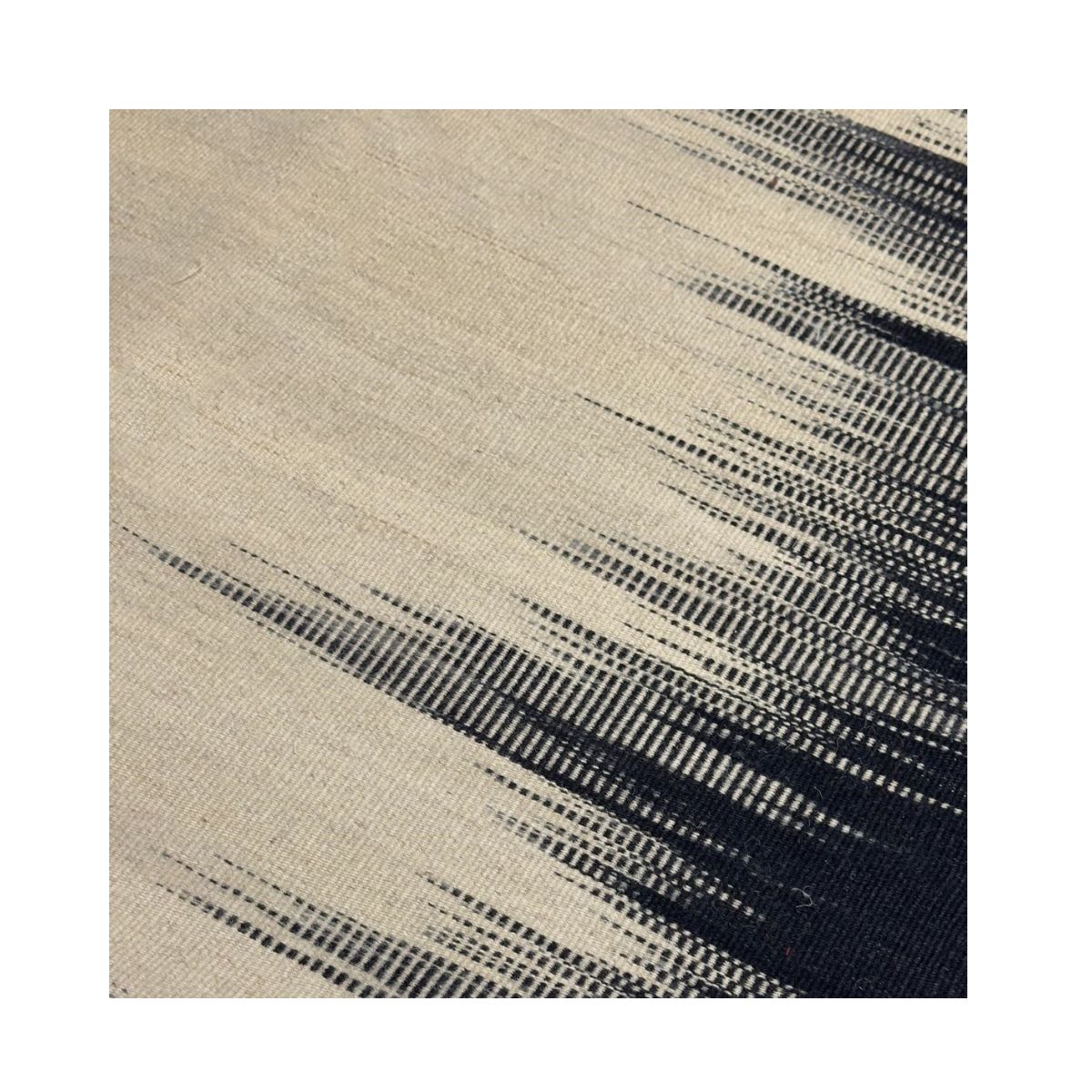 Tapete de tecido tecido à mão em bege com desenho abstrato preto em gradientes.