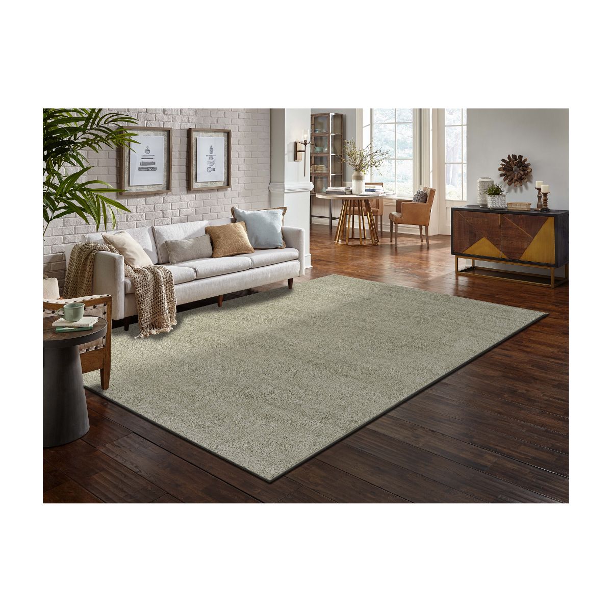 Sala de estar moderna e aconchegante com sofá cinza, parede de tijolos e plantas decorativas.