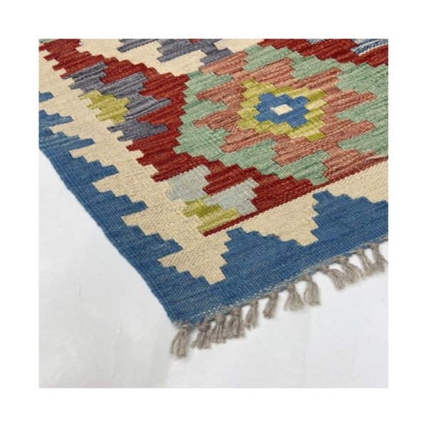 Tapete Kilim artesanal detalhado com padrões geométricos e tons terrosos.