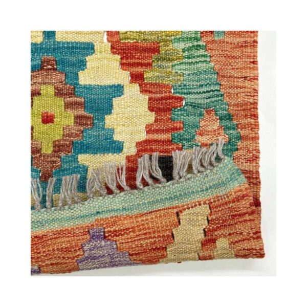 Tapete kilim artesanal com padrões geométricos coloridos e textura de lã visível.