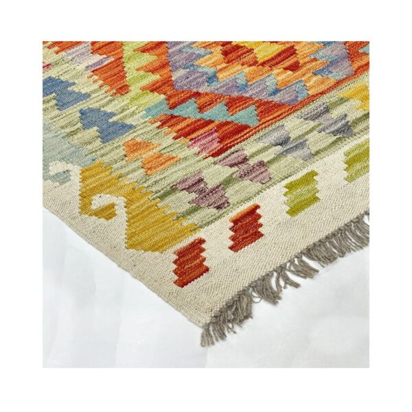 Tapete artesanal colorido com padrões geométricos intrincados e franjas decorativas.
