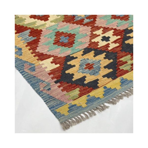 Tapete kilim artesanal com padrões geométricos e cores vibrantes.