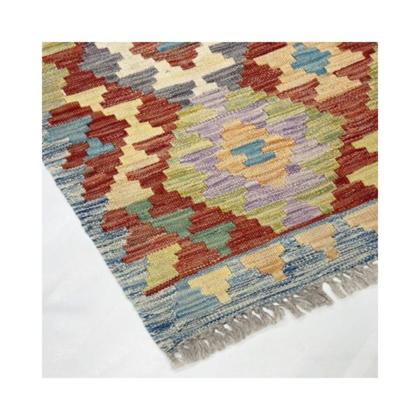 Tapete artesanal vibrante com design geométrico e cores terrosas.