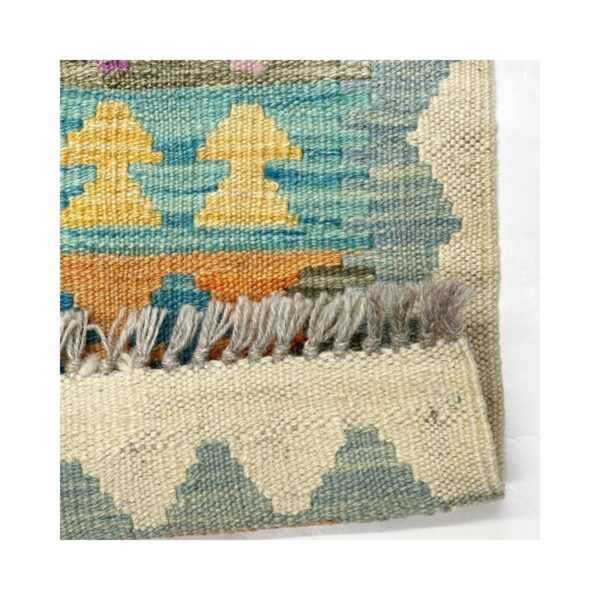 Tapete de kilim artesanal com padrões geométricos e franjas detalhadas.