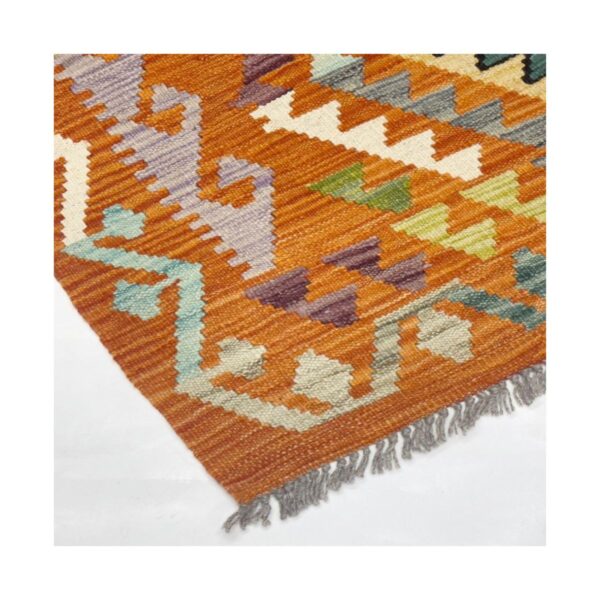 Tapete artesanal com padrões geométricos e cores vibrantes em laranja, azul e verde.