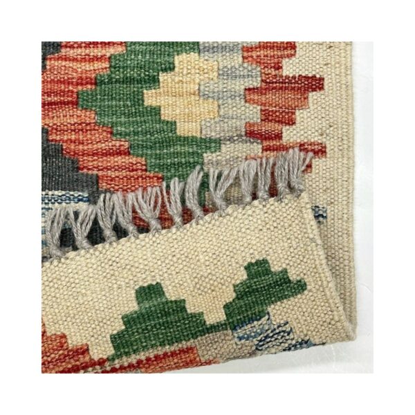 Tapete de kilim feito artesanalmente com padrão geométrico e cores vibrantes.