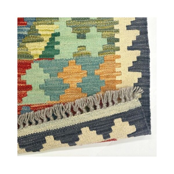 Tapete kilim artesanal com padrão geométrico e cores vibrantes.