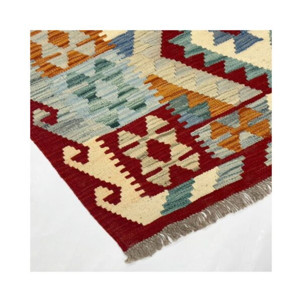 Tapete kilim vermelho artesanal com detalhes geométricos e franja cinza.
