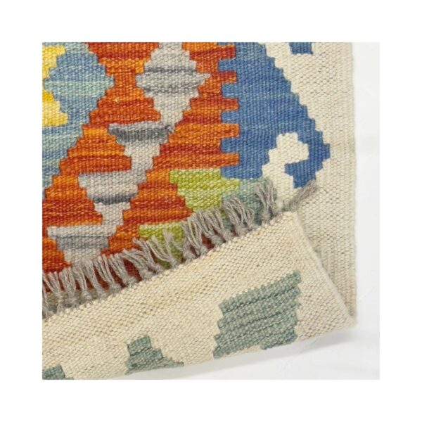 Tapete kilim artesanal com padrões geométricos vibrantes em lã.