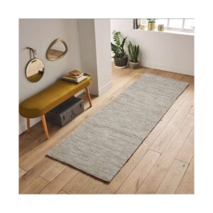 Espaço minimalista com banco amarelo, espelhos decorativos e plantas perto de uma janela grande.