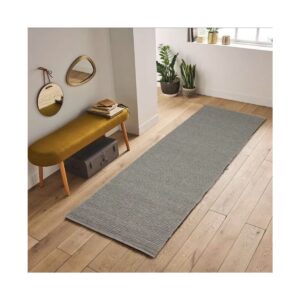 Ambiente minimalista com banco amarelo, espelhos redondos e plantas verdes na janela.