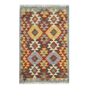 Tapete geométrico artesanal em vermelho, amarelo e azul com design inspirado em kilim.