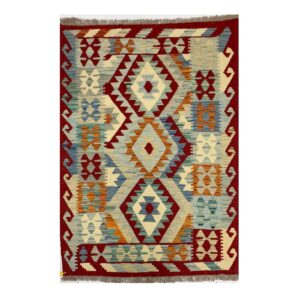 Tapete artesanal com design geométrico e cores vivas e terrosas em estilo kilim tribal.