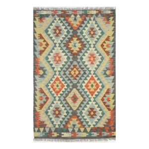 Tapete kilim com desenho geométrico e cores terrosas.
