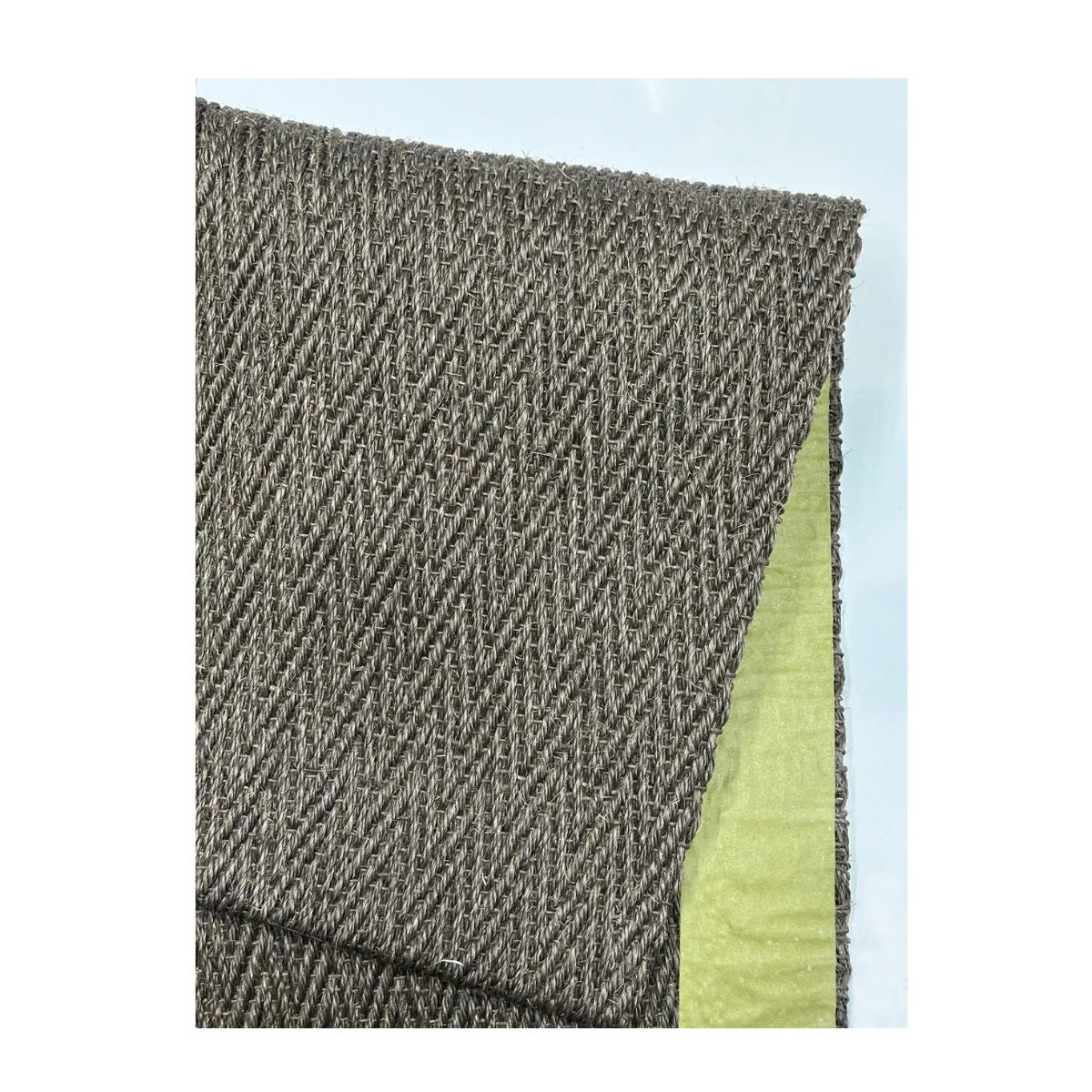 Peça de tecido tecido em zigue-zague marrom e verde, com subcamada lisa e destaque para textura.